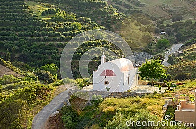 Idyllic rural landscape with hills covered by olive trees and tiny peaceful orthodox church in beautiful sunset light, Crete, Stock Photo