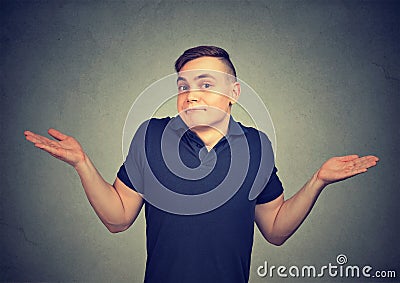 Ignorance. Man shrugging shoulders who cares so what isolated on gray background. Stock Photo