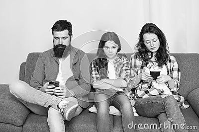 Ignored child. Busy parents surfing internet smartphones. Dad and mom ignoring daughter needs. Bad habits. Parenthood Stock Photo