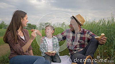 Il divertimento di svago della famiglia, coppie di risata allegre con il ragazzo del bambino mangia la mamma delle alimentazioni stock footage Il divertimento di svago della famiglia, coppie di risata allegre con il ragazzo del bambino mangia la mamma delle alimentazioni stock footage