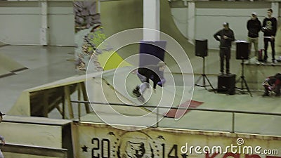 Il pattinatore del rullo fa il salto in alto, piede della gru a benna in aria Slittamento sul trampolino Concorrenza nello skatep archivi video Il pattinatore del rullo fa il salto in alto, piede della gru a benna in aria Slittamento sul trampolino Concorrenza nello skatep archivi video