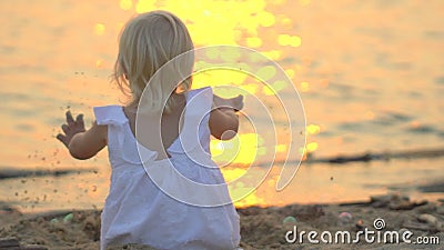 Il piccolo bambino si siede sulla spiaggia durante il tempo di vacanza felice del bello tramonto al rallentatore Bambino diverten stock footage Il piccolo bambino si siede sulla spiaggia durante il tempo di vacanza felice del bello tramonto al rallentatore Bambino diverten stock footage