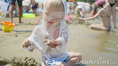 Il ragazzino carino che gioca con la sabbia sulla spiaggia di mare Bambino in vacanza in estate in spiaggia in vacanza archivi video Il ragazzino carino che gioca con la sabbia sulla spiaggia di mare Bambino in vacanza in estate in spiaggia in vacanza archivi video