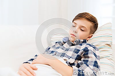 Ill boy with flu lying in bed at home Stock Photo