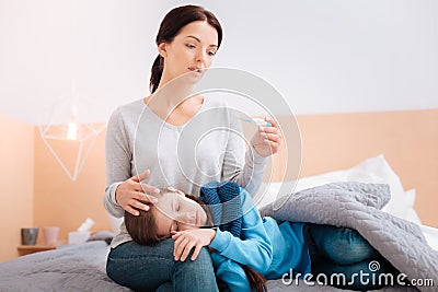 Ill child on the knees of a worried mother Stock Photo