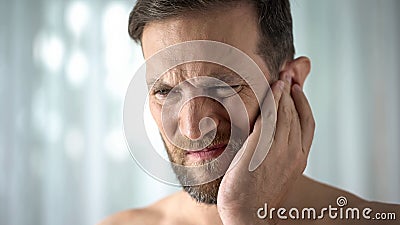 Ill man feeling ear pain, health care, neurological infection, itchiness otitis Stock Photo