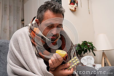 Ill man wearing scarf sad expression looking at lemon Stock Photo