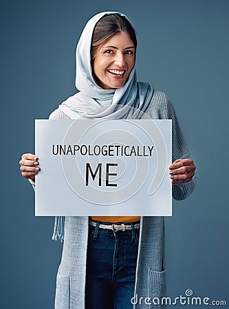 Ill never apologize for being myself. Studio portrait of an attractive young woman holding up a sign reading Stock Photo