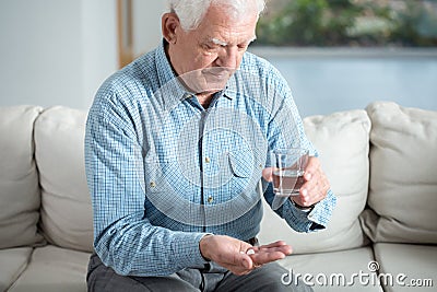 Ill senior man taking pill Stock Photo