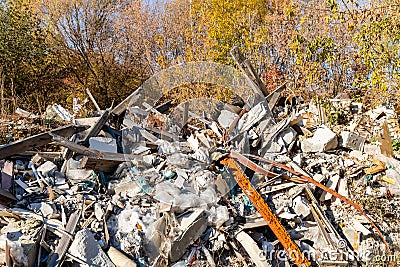 Illegal construction waste dump. Pieces of concrete, fragments of walls, broken bricks, steel reinforcement, plastic Stock Photo