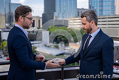 Illegal corruption, bribery concept. Two business team men. Businessmen giving money. Business man offering money for Stock Photo