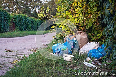 Illegal garbage dump on a dirt road, plastic and other waste. Dangerous pollution of nature Stock Photo