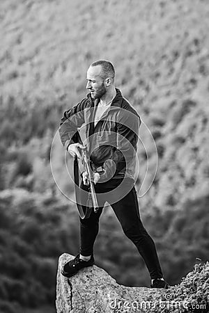 Illegal hunting. Poaching concept. Poacher stand on edge of cliff. Man brutal poacher with weapon natural landscape Stock Photo