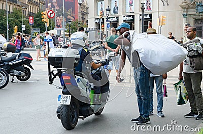 Illegal trade of souvenirs on Plaza Catalunya, Barcelona, Spain Editorial Stock Photo