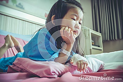Illness asian child admitted in hospital with saline iv drip on Stock Photo