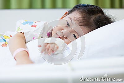 Illness child in hospital, saline intravenous (IV) on hand asian Stock Photo