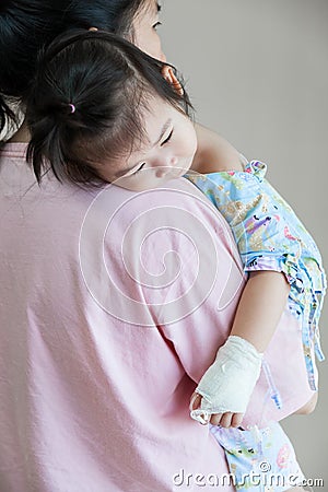 Illness child in hospital, saline intravenous (IV) on hand asian Stock Photo