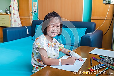 Illness girl with saline intravenous IV on hand. Girl Drawing on a white paper Stock Photo