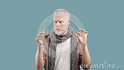 Illness treatment. Sick albino man holding pill and glass of water, taking medicine over turquoise background Stock Photo