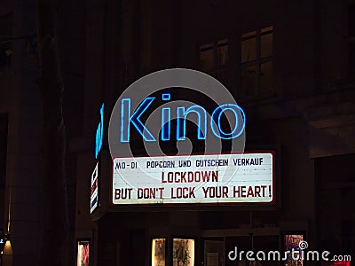 Illuminated billboard above cinema closed due to Covid-19 lockdown in city center with slogan. Editorial Stock Photo