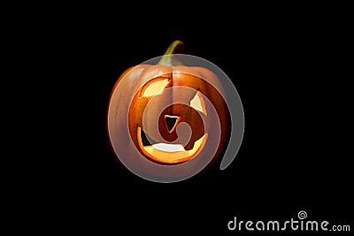 Illuminated carved pumpkin isolated on a black background Stock Photo