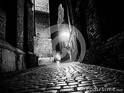 Illuminated cobbled street in old city by night Stock Photo