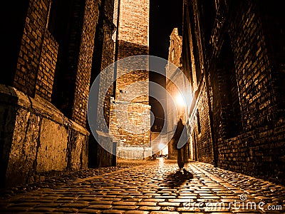 Illuminated cobbled street in old city by night Stock Photo