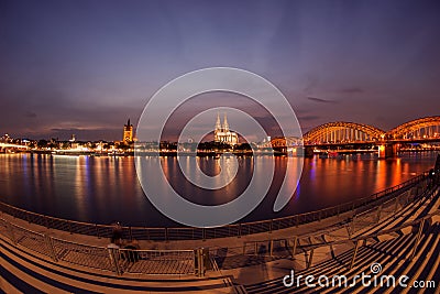 Illuminated Cologne Cathedral and bridge at night in Cologne Stock Photo