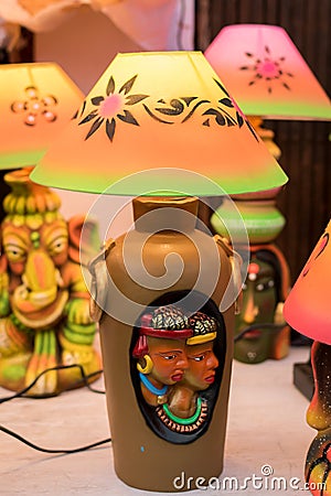 An illuminated decorative handmade table lamp is displayed in a street shop for sale. Indian handicraft and art Editorial Stock Photo