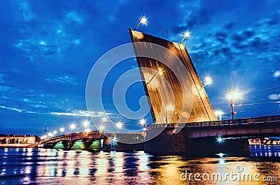 An illuminated drawbridge in Saint Petersburg at white night and reflections on water Stock Photo