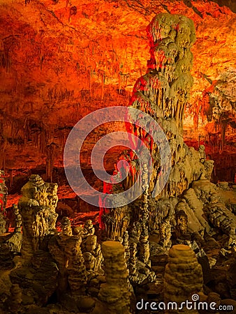 Illuminated dripstones in cave Stock Photo