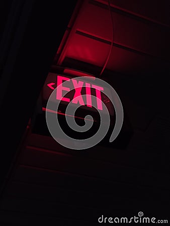 Illuminated Exit sign with red light Stock Photo
