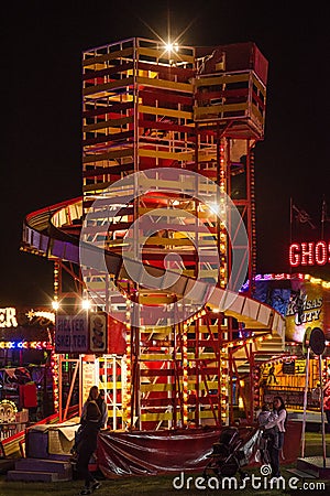 Illuminated, helter skelter ride at a funfair. 4 Editorial Stock Photo