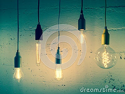 Illuminated light bulbs on green background Stock Photo