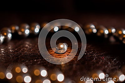 Illuminated metal ball from the bearing in the circle of other balls. Stock Photo