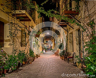 The illuminated narrow alley Antoniou Gampa with flowers and balconies in the old town of Chania Editorial Stock Photo