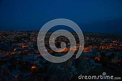 Illuminated at night streets of Goreme, Turkey, Cappadocia. The famous center of flight balloons. On the horizon - highlighted Stock Photo