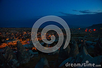 Illuminated at night streets of Goreme, Turkey, Cappadocia. The famous center of flight balloons. On the horizon - highlighted Stock Photo