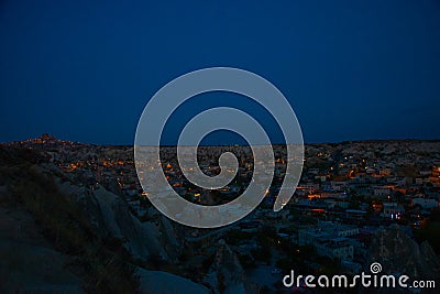 Illuminated at night streets of Goreme, Turkey, Cappadocia. The famous center of flight balloons. On the horizon - highlighted Stock Photo