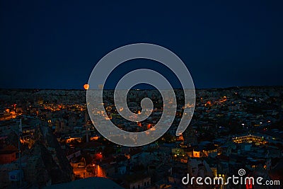 Illuminated at night streets of Goreme, Turkey, Cappadocia. The famous center of flight balloons. On the horizon - highlighted Stock Photo