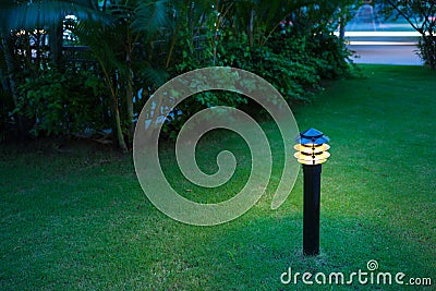 Illuminated outdoor light in apartment garden at twilight, evening. Stock Photo