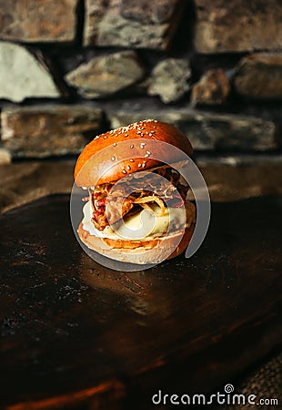 Illuminated photo of american hamburger with chuck roll meat, cheddar cheeese and other ingredietns on dark background Stock Photo