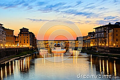 Illuminated Ponte Vecchio with reflections at sunset, Florence, Tuscany, Italy Stock Photo