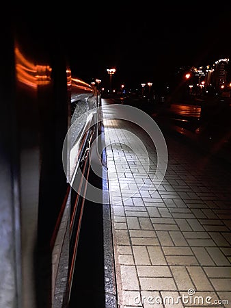 Illuminated road, night city. A narrow strip of light from the lanterns. Stock Photo