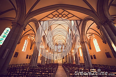 Illuminated Roman Catholic Church with Stained Glass Windows Stock Photo