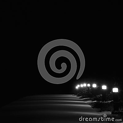 Illuminated Snowy Park Footpath Lights, Bright Lit White Outdoor Pathway Pavement Lanterns Lampposts Row Perspective At Night Stock Photo