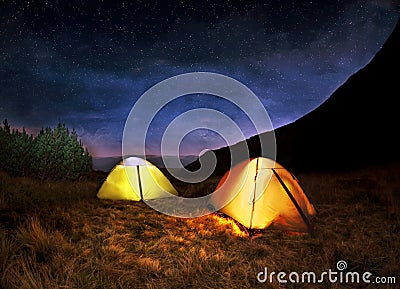 Illuminated yellow camping tent under stars Stock Photo