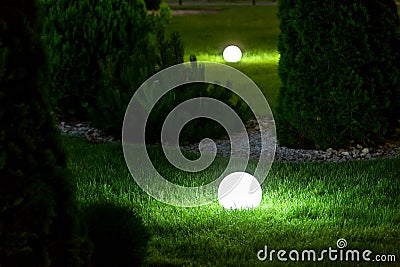 Illumination backyard light garden with electric ground lantern with sphere diffuser. Stock Photo