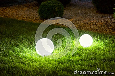 Illumination backyard light garden with 2 electric ground lanterns. Stock Photo