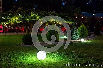 Illumination backyard light garden with electric ground sphere lantern. Stock Photo